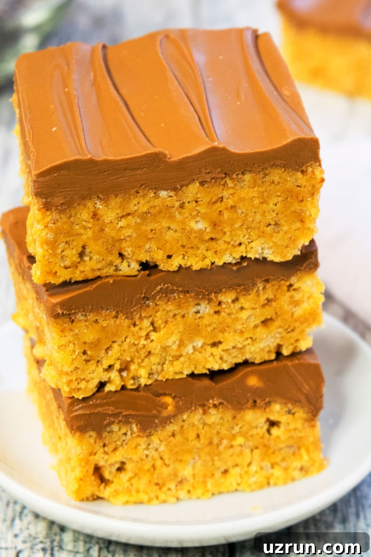 Stacked Slices of No Bake Easy Scotcheroos Without Corn Syrup on White Dish.