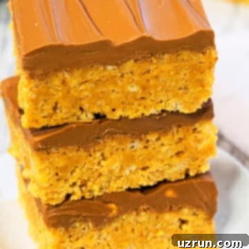Easy Scotcheroos Without Corn Syrup 8 Stacked Slices of Easy Scotcheroos Without Corn Syrup on White Dish.