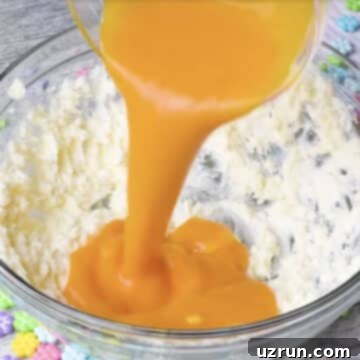 Easy Mango Buttercream Frosting 6 Mango puree being poured into the butter mixture.