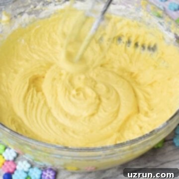 Easy Mango Buttercream Frosting 9 Hand held mixer mixing all the ingredients until smooth.