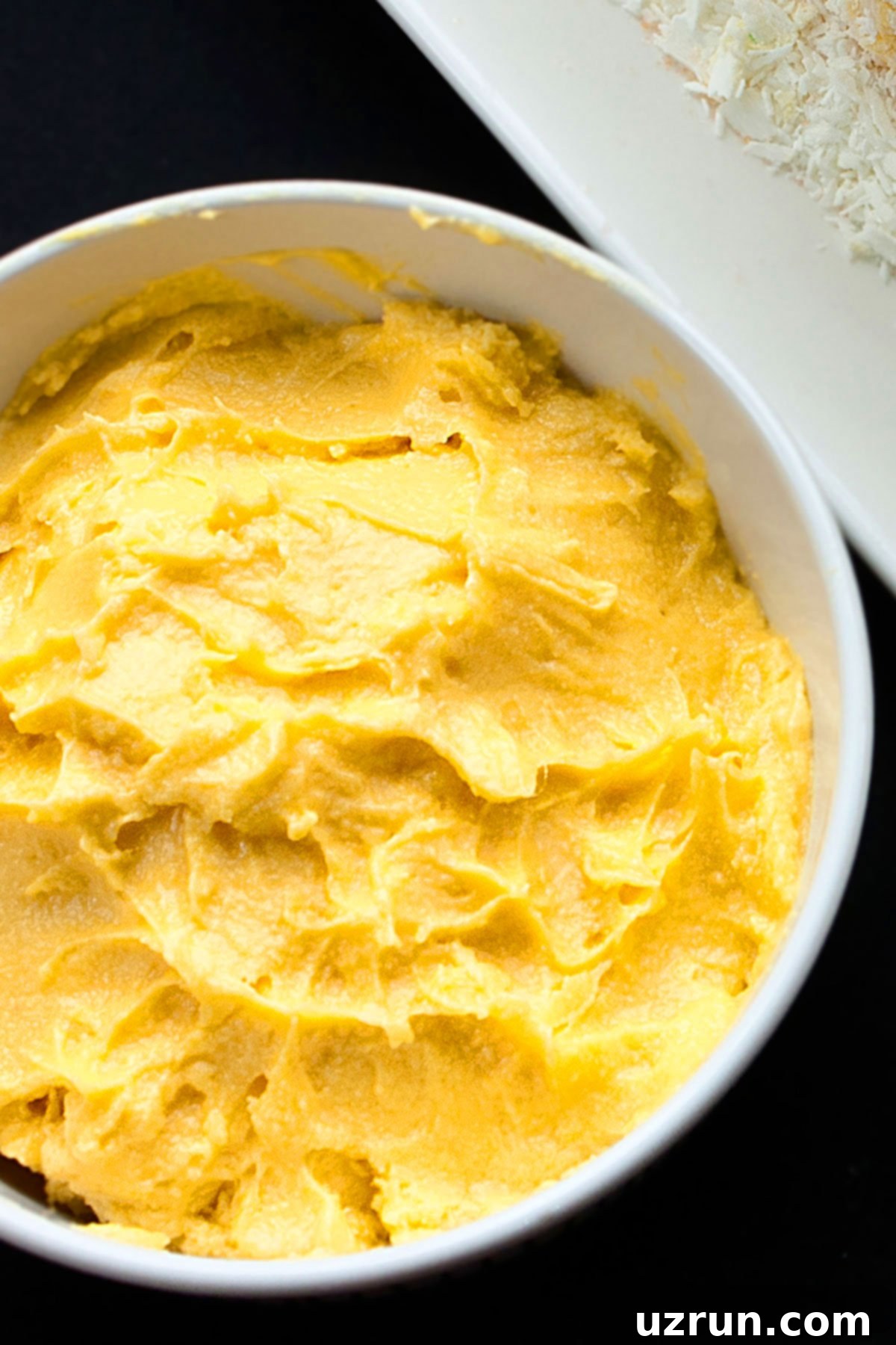 Easy Mango Buttercream Frosting 10 Mango buttercream frosting in white bowl.