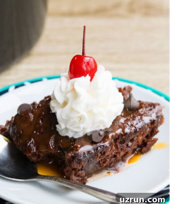 Easy Box Mix Slow Cooker Chocolate Lava Cake 4 Self Saucing Chocolate Pudding Cake With Whipped Cream on White Dish. A perfectly set chocolate cake with a rich sauce underneath, garnished with fresh whipped cream.