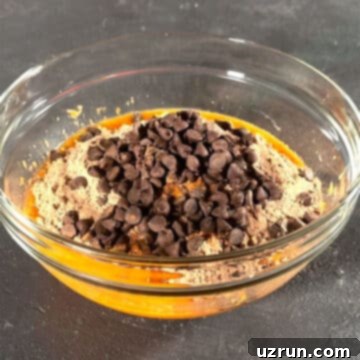 Semi-Homemade Carrot Brownies 6 Glass bowl with orange mixture, brownie mix and chocolate chips.