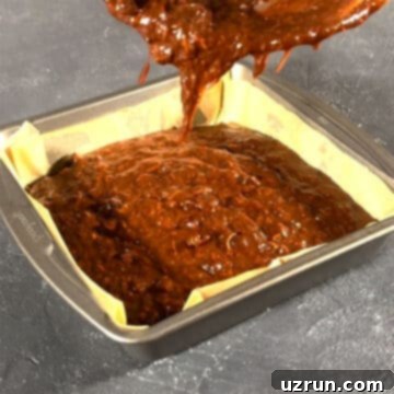 Semi-Homemade Carrot Brownies 8 Brownie batter being poured in a lined square pan.