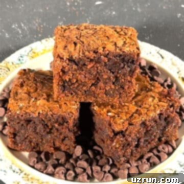 Semi-Homemade Carrot Brownies 9 Slices of fudgy brownies stacked on top of each other on a rustic dish.
