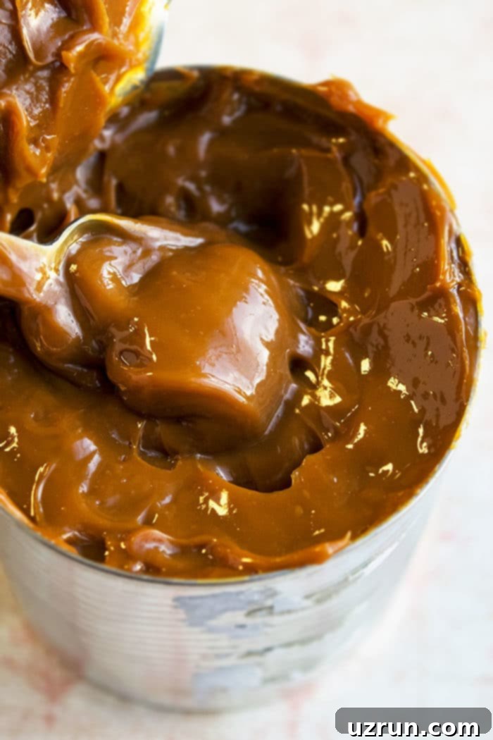 Can of Homemade Dulce De Leche With Condensed Milk on White Marble Background. 