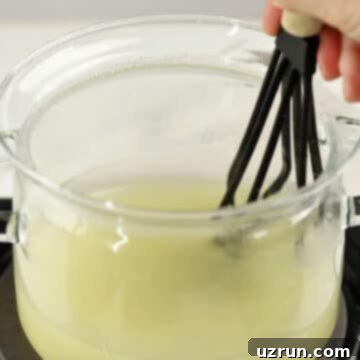 Lemon Meringue Pie That Never Weeps 4 Water, cornstarch, lemon juice, sugar, lemon zest being whisked in glass pot.