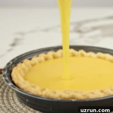 Lemon Meringue Pie That Never Weeps 8 Lemon filling being poured into a crust.