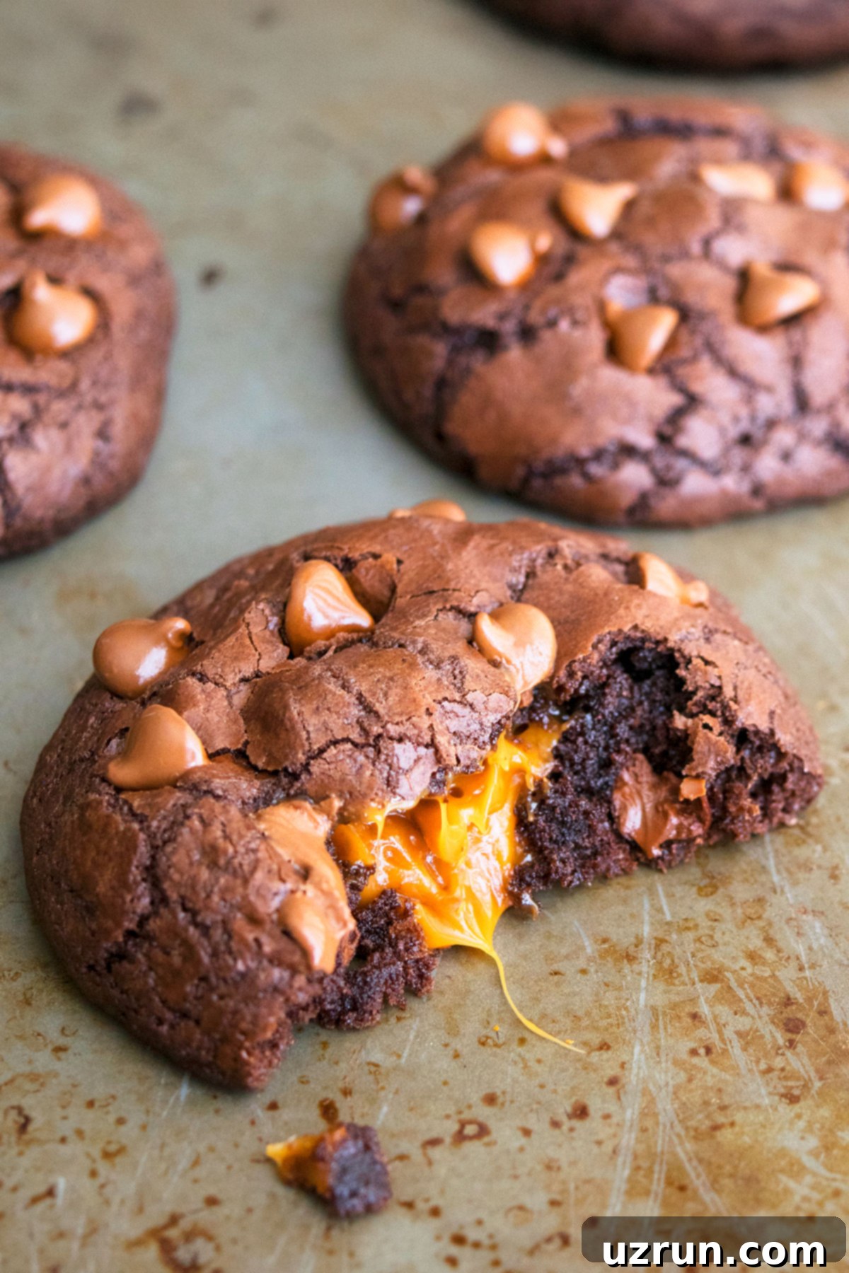 Stuffed Chocolate Caramel Cookies 3 Partially Eaten Cookie With Caramel Filling Oozing out From the Center.