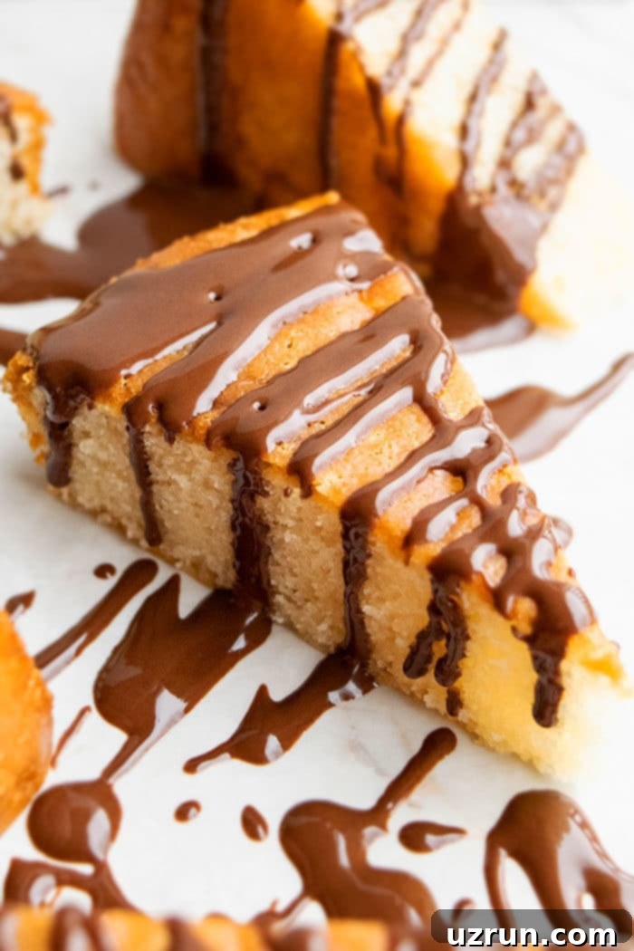 Slice of Honey Cake From Scratch With Chocolate Drizzle on White Marble Background. 