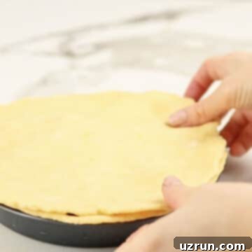 Easy Blueberry Pie With Fresh Or Frozen Berries 8 Pie crust being spread over the filling.