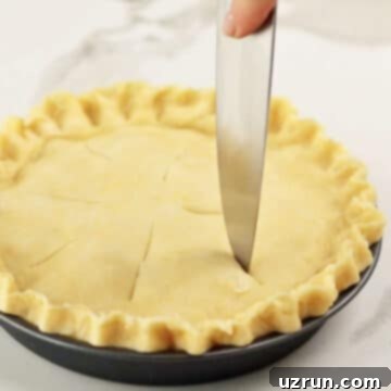 Easy Blueberry Pie With Fresh Or Frozen Berries 10 Knife being used to make cuts for venting on top of pie crust.
