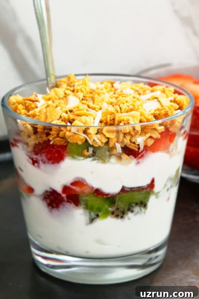 Homemade Yogurt Parfait in Glass Cup With Fresh Fruits and Granola Layers.