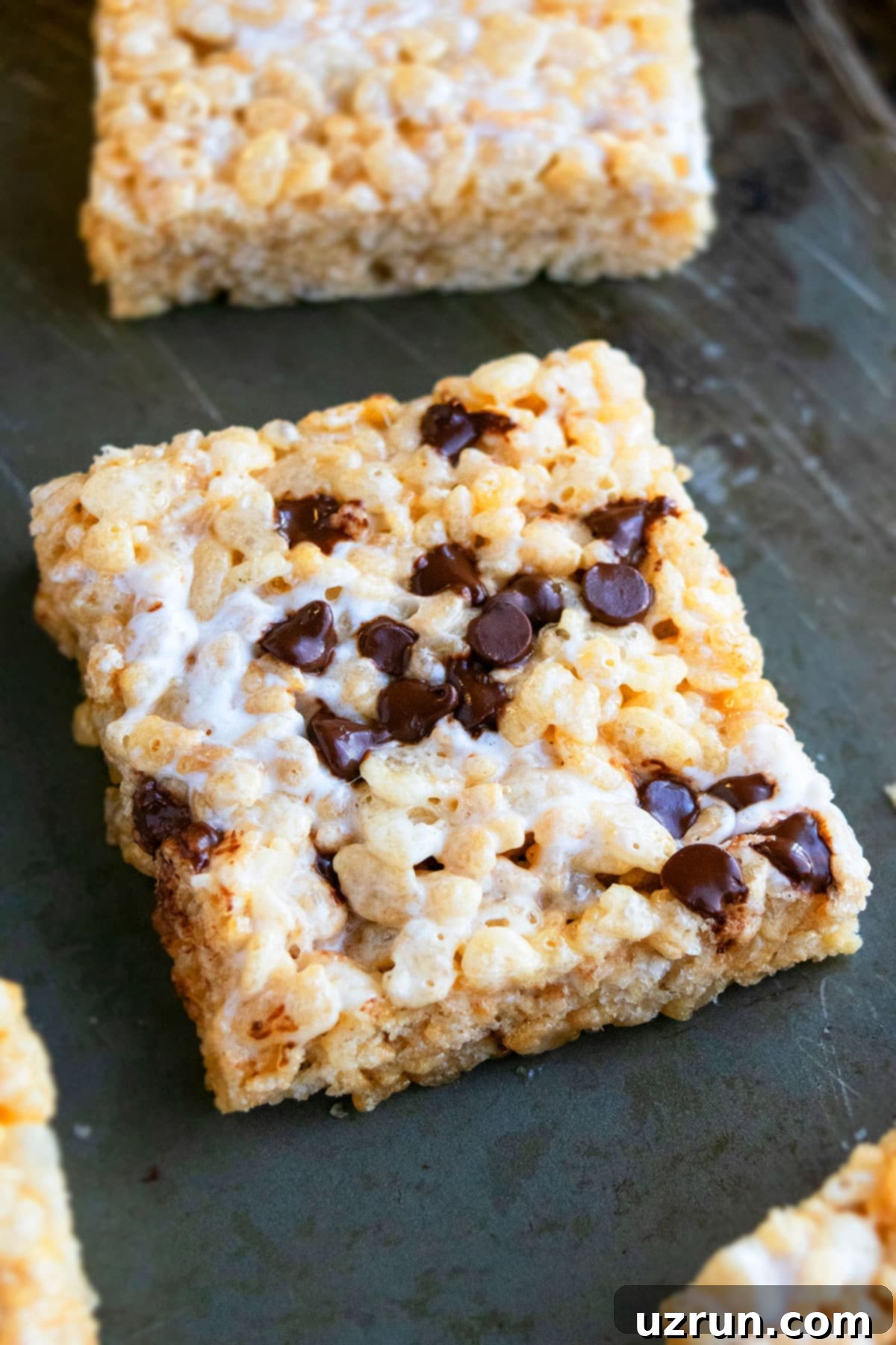 The Ultimate Guide to Perfect Rice Krispie Treats 12 Sticky Cereal Bar With Chocolate Chips on Gray Background.