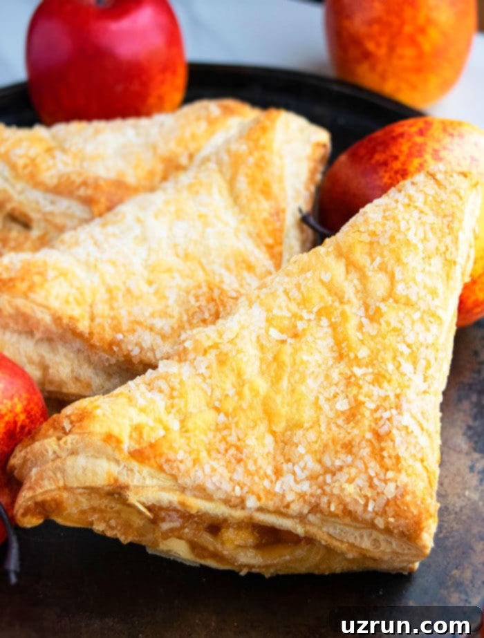 Flaky Apple Turnovers with Puff Pastry 4 Homemade Apple Puff Pastry on Dark Baking Tray.