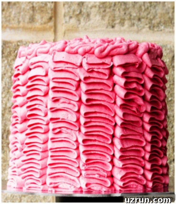 Mastering the Buttercream Ruffle Cake 4 Decorated Pink Cake on Cake Stand with Brick Background