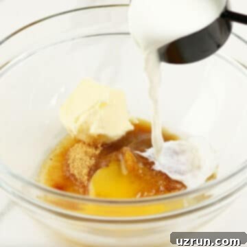Baked Apple Cider Cake Donuts 5 Milk being poured in glass bowl with eggs, butter, sugar and vanilla.