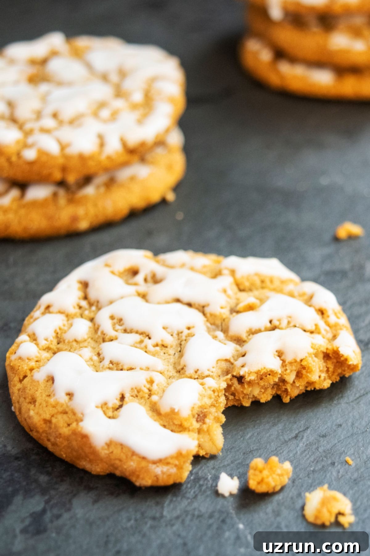 Vanilla Glazed Oatmeal Cookies 5 Closeup Shot of Half Eaten Oatmeal Cookie on Gray Background With Vanilla Glaze Icing.
