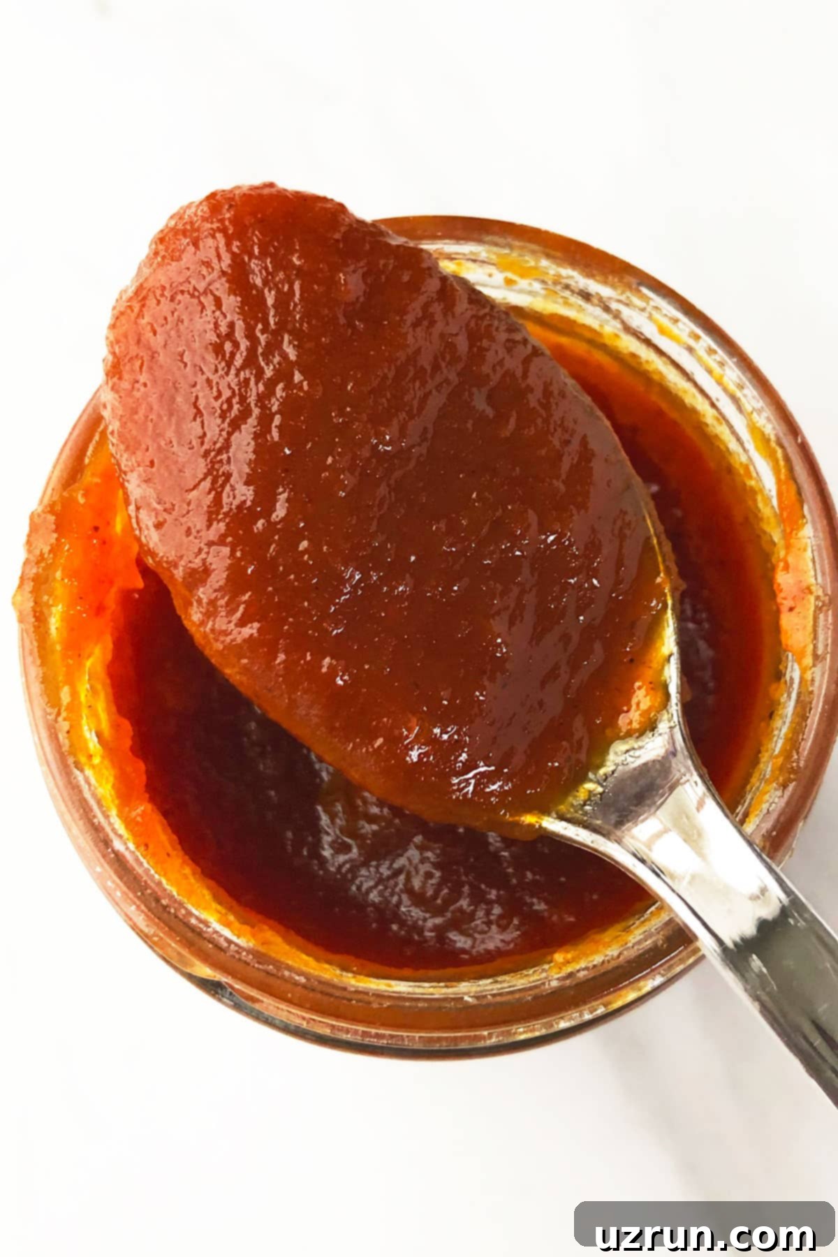 Simple 5-Ingredient Crockpot Pumpkin Butter 3 Spoonful of Spiced Butter on Top of Glass Jar.