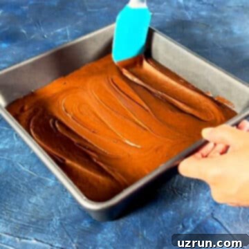 Easy Brookies with Brownie Mix 9 Brownie batter being spread with rubber spatula in baking pan.