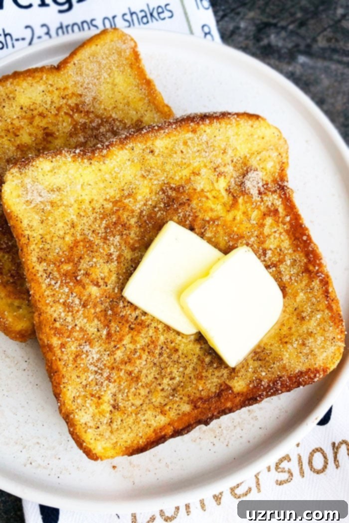 Easy Cinnamon French Toast on White Plate Topped with Sliced Butter