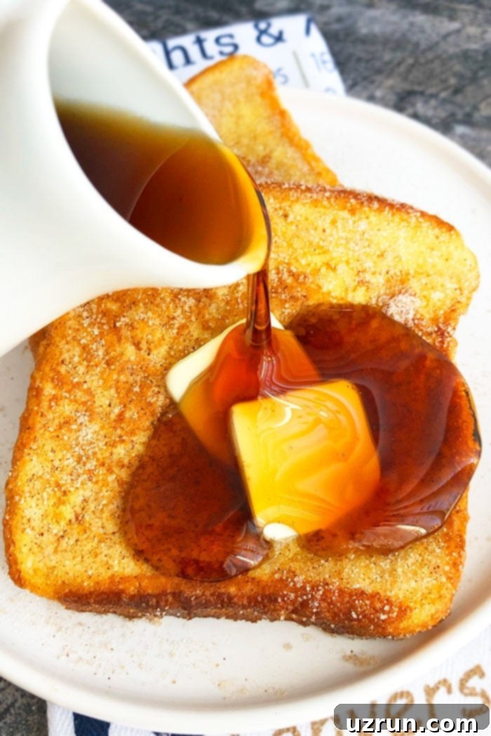 Quick Cinnamon French Toast 3 Syrup Being Poured on Fluffy French Toast on White Plate