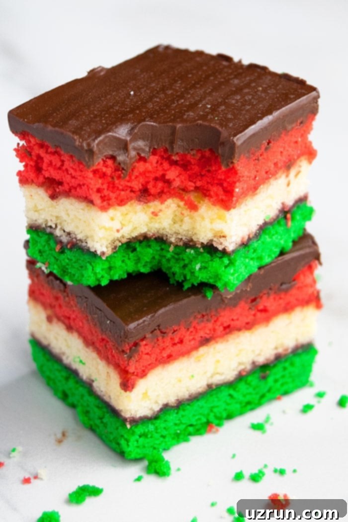 Vibrant Italian Rainbow Almond Delights 3 Stack of Two Italian Venetian Cookies or Neapolitan Cookies With a Bite Removed From Top Slice on White Background