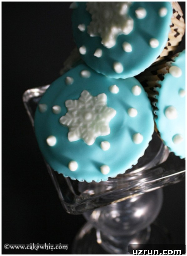 Winter Wonderland Cupcakes 3 Homemade Winter Cupcakes Stacked on Top of One Another on Glass Stand, showing various angles of the snowflake decorations.