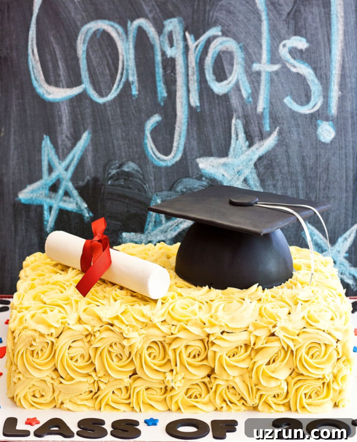 Easy Graduation Cake with Cap and Diploma 3 Close-up of a Decorated Graduation Cake with an Edible Diploma and Cap Against a Chalkboard.