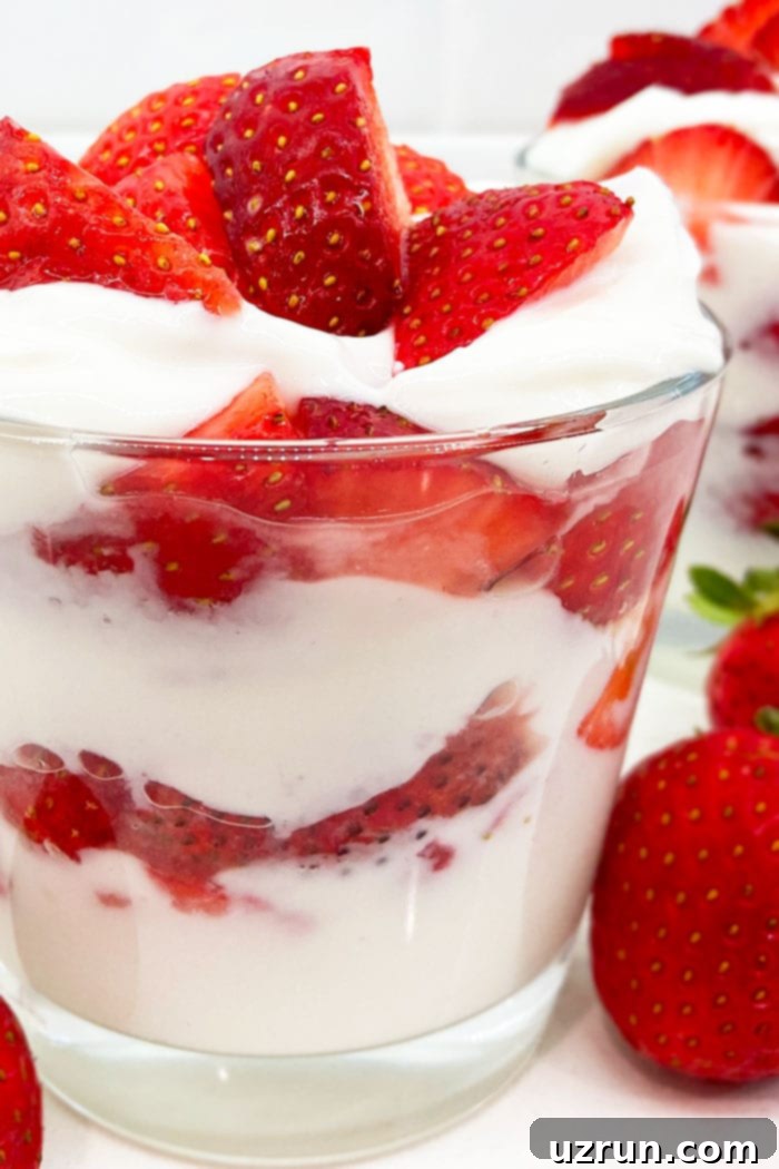 Creamy No-Bake Strawberry Treat 4 Closeup Shot of Layers of Fresh Strawberries and Whipped Cream in Glass Cup, showing texture and detail
