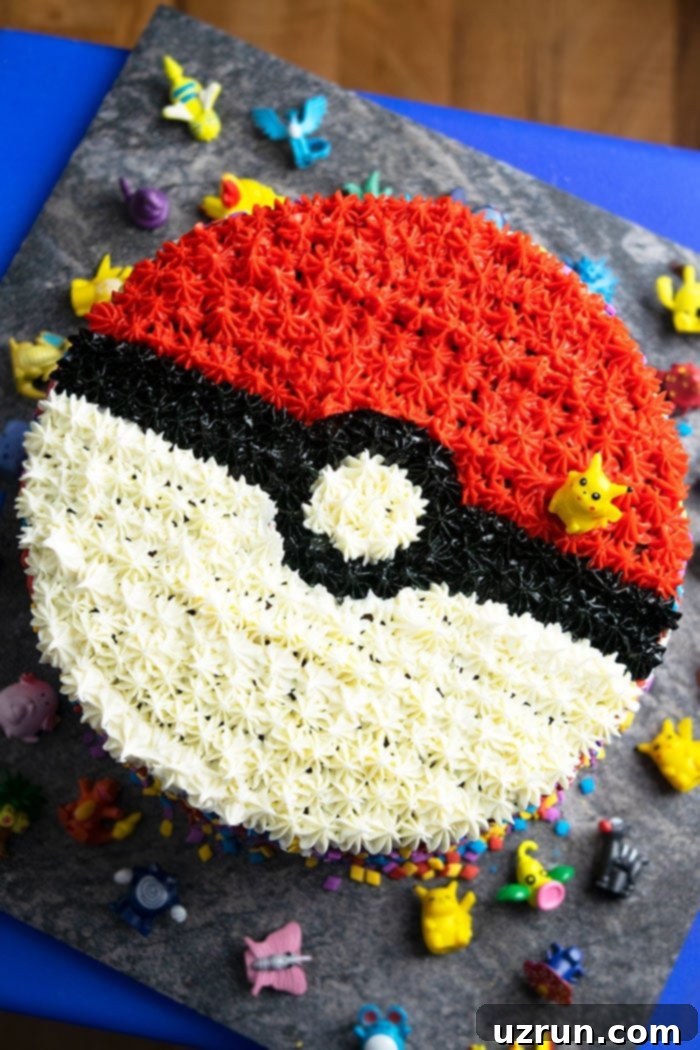 Easy Pokeball Cake on Gray Plate- Overhead Shot, showcasing a perfectly round, red and white cake with a black stripe, designed to look like a Pokeball.