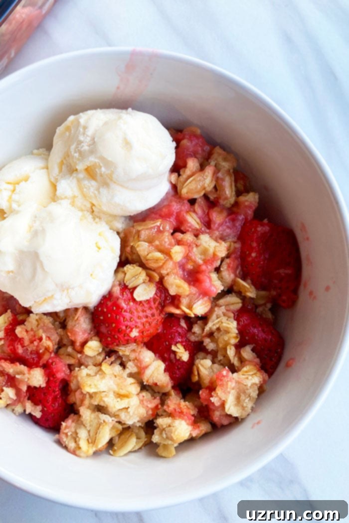 Sweet Strawberry Crumble 3 White Bowl Filled With Fresh Strawberries and Oats Crunch Topping and Vanilla Ice Cream- Overhead Shot