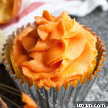 Easy Orange Buttercream Frosting 7 Easy Orange Frosting (Buttercream Icing) on Top of Cupcake on Rustic Gray Background.