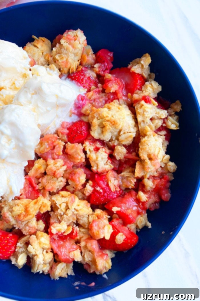 Strawberry Rhubarb Crisp 4 Rhubarb and Strawberry Crumble or Crisp in Blue Bowl on White Marble Background