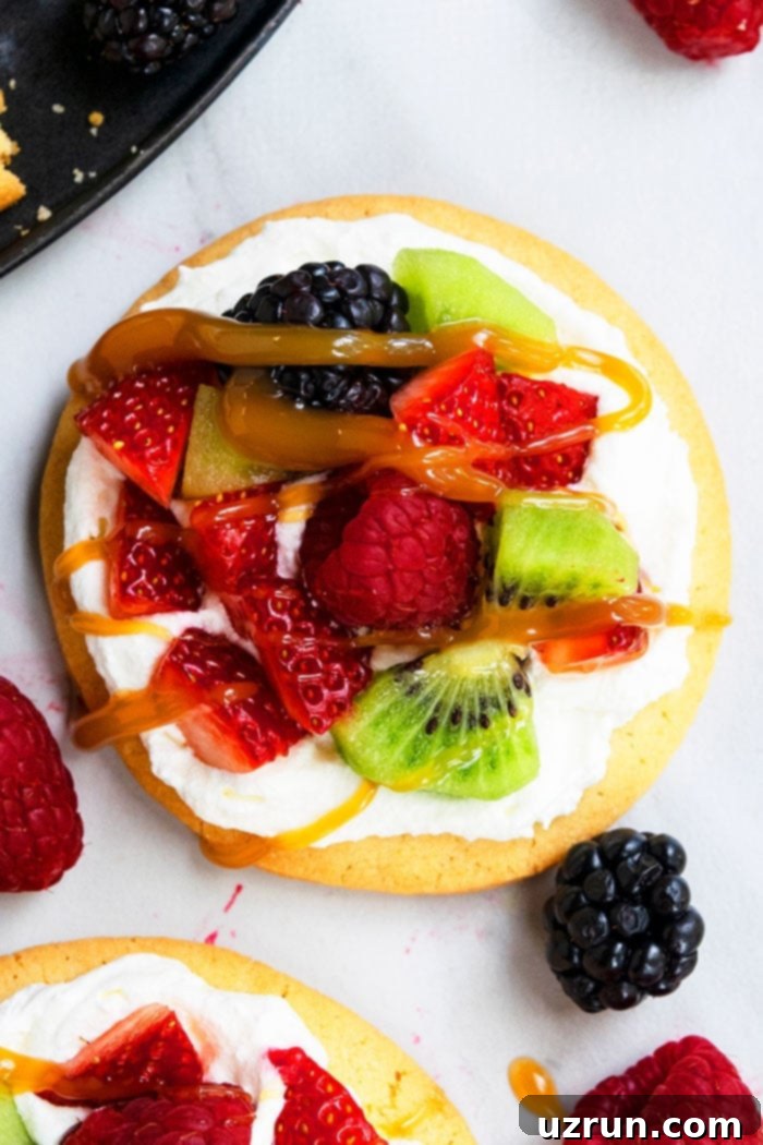 Sweet Mini Fruit Pizzas 3 Soft and Chewy Sugar Cookie Pizza on Marble Background- Overhead Shot