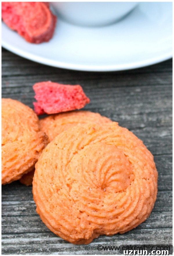 Easy Piped Rose Cookies 4 Piped Spiral Orange Cookies on Rustic Gray Background