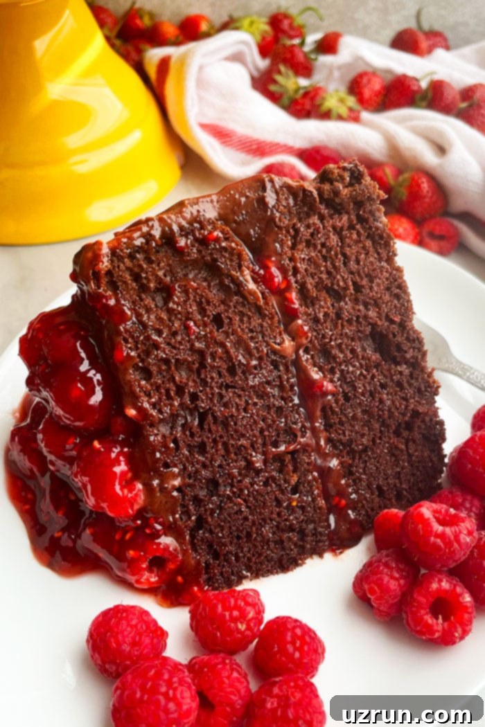 Luscious Chocolate Raspberry Cake Made Easy 4 Slice of Summer Cake on White Plate With Raspberries and Strawberries Scattered Around