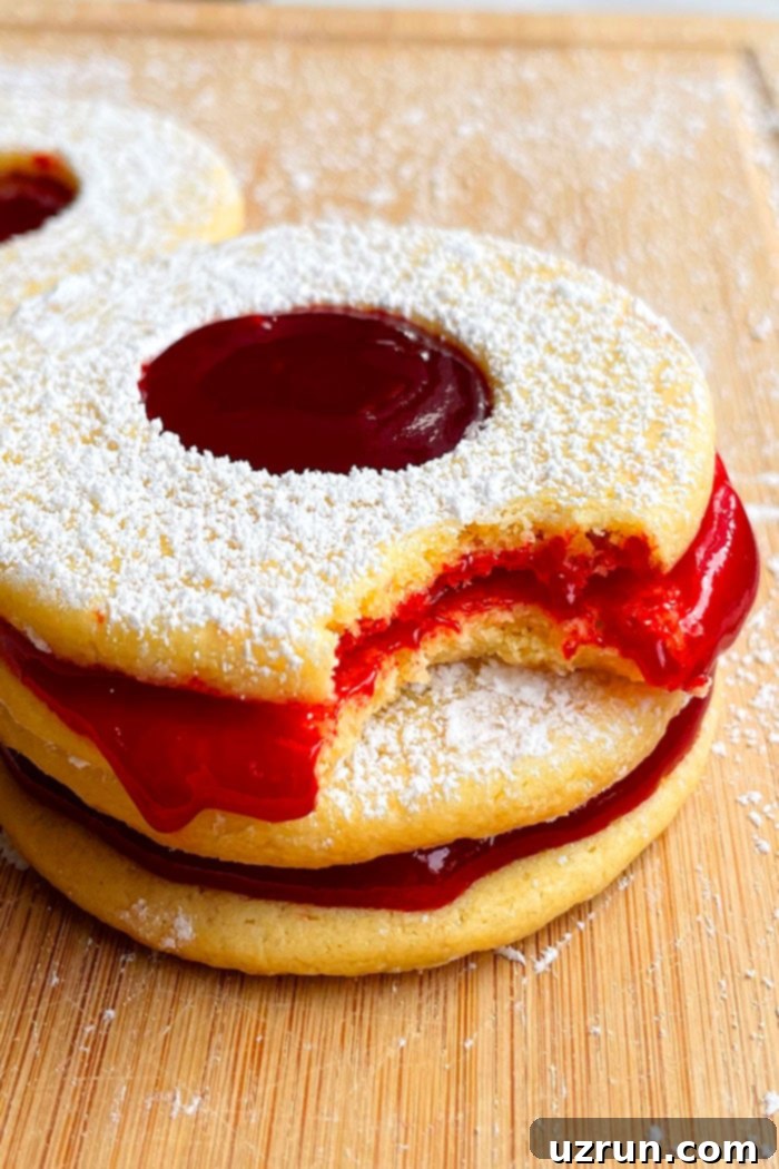 Jam-Filled Shortbread Linzer Cookies 3 Stack of Raspberry Shortbread Linzer Cookies on Wood Background