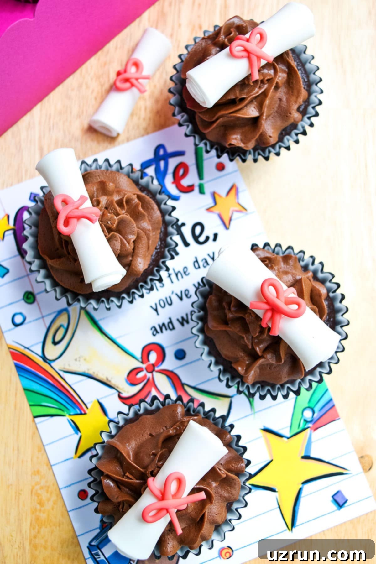 Easy Graduation Cupcakes with Diploma Toppers 3 Overhead Shot of Decorated Cupcakes on Wood Table With Colorful Grad Card.