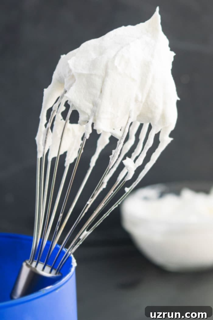 Perfect Stabilized Homemade Whipped Cream 3 Best Homemade Cool Whip on Whisk With Gray Background.