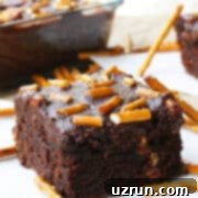 Cake Mix Desserts Made Easy 82 Slice of Easy Fudgy Chocolate Cake Mix Brownies With Ganache and Pretzels on White Napkin.