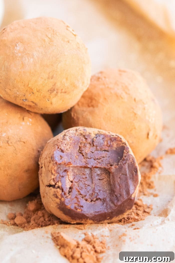 Easy 4-Ingredient Champagne Truffles 2 Homemade Chocolate Champagne Truffles on Brown Paper - Partially Eaten