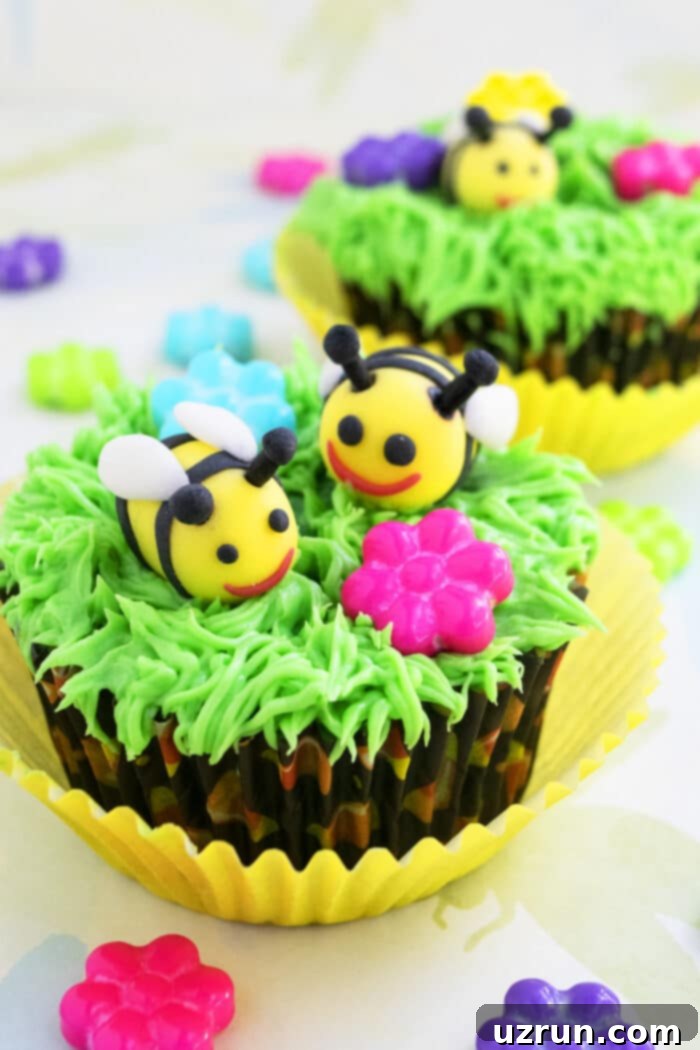 Easy Bumblebee Cupcakes with vibrant green grass icing and adorable 3D fondant bees on a light yellow background, perfect for spring and birthdays.