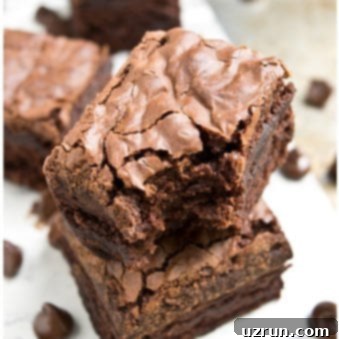 Achieving Perfect Fudgy Brownies with Crinkled Tops 7 Stack of Easy Fudgy Brownies With Crackly Tops on White Dish.