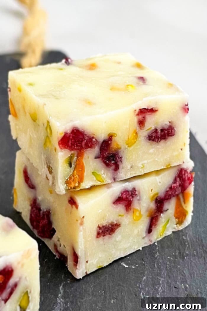 Stack of Easy Sweetened Condensed Milk Fudge With Cranberries, Pistachios on Black Base