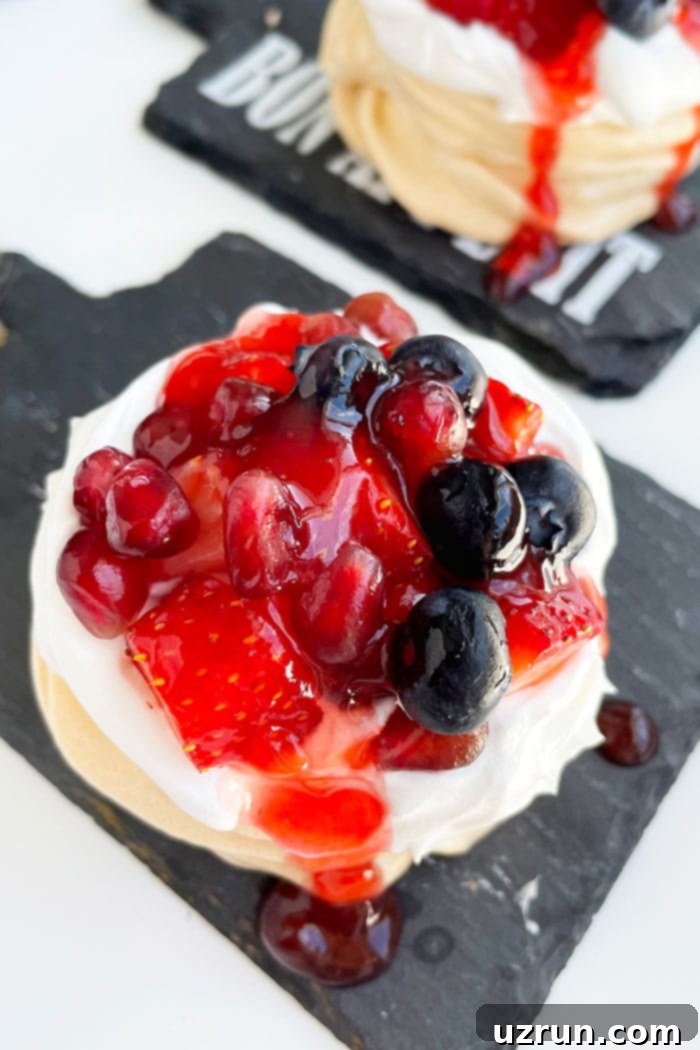 Mini Pavlovas with Whipped Cream and Berries 3 Closeup Shot of Whipped Cream and Fresh Berry Toppings on Mini Meringue, showing the intricate details of the fruit and cream over the crispy pavlova.