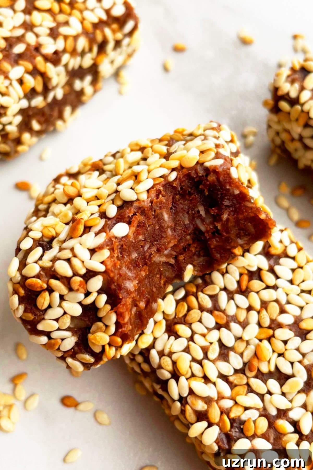 No-Bake Date Bars 12 Partially Eaten No Bake Sesame Bars on Dull White Background.