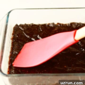 No-Bake Date Bars 7 Sticky date mixture being spread in glass pan.
