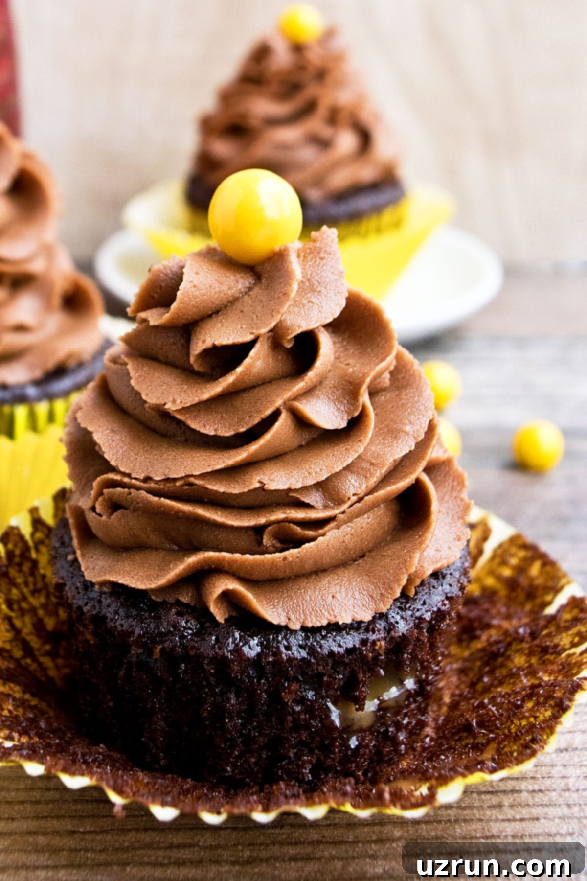 Easy Chocolate Coffee Cupcakes (Mocha Cupcakes) With Liner Partially Removed on Wood Background.