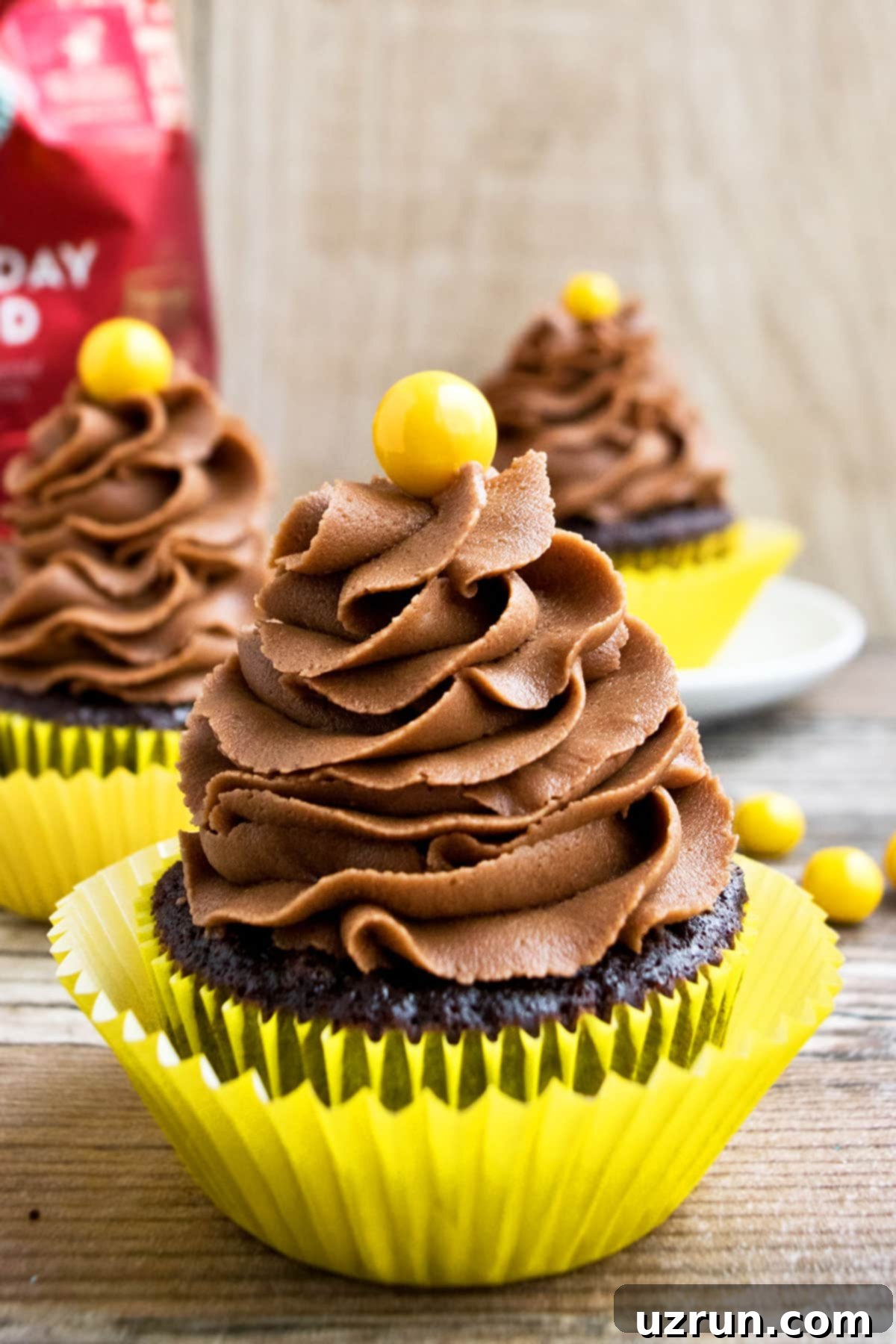 Mocha Coffee Cupcakes 3 Homemade Mocha Cupcakes in Yellow Liner on Rustic Background.